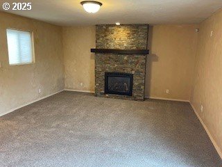 unfurnished living room with a stone fireplace