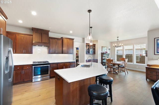1705 Trevino Rd, Creswell, OR 97426 - kitchen with stainless steel appliances, a sink, a kitchen island with sink, light countertops, and tasteful backsplash