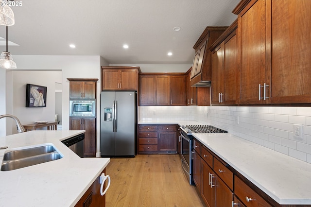 1705 Trevino Rd, Creswell, OR 97426 - kitchen featuring stainless steel appliances, a sink, light countertops, light wood finished floors, and hanging light fixtures