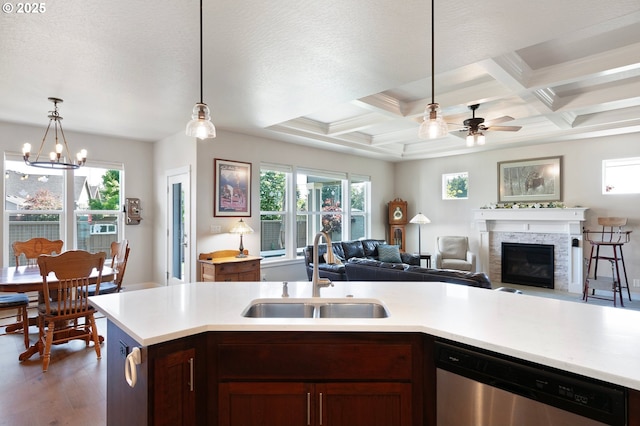 1705 Trevino Rd, Creswell, OR 97426 - kitchen featuring a sink, dishwasher, light countertops, a glass covered fireplace, and a ceiling fan