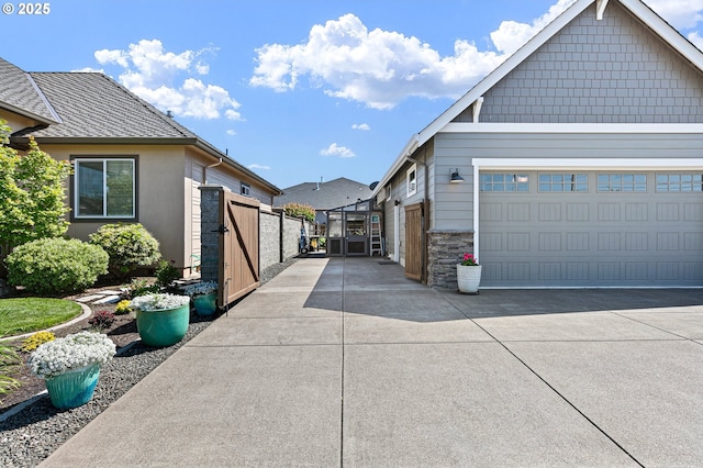 1705 Trevino Rd, Creswell, OR 97426 - view of property exterior with a gate, concrete driveway, and stone siding