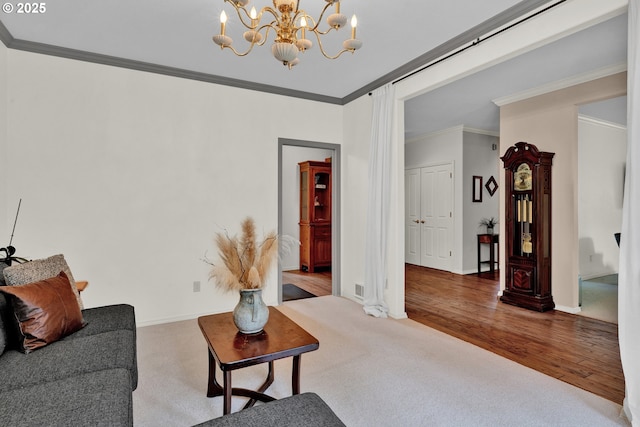 living room with ornamental molding, a chandelier, carpet, and baseboards