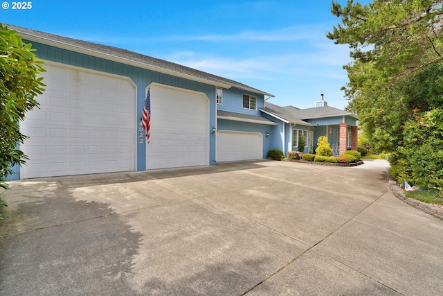 view of front facade featuring driveway, a garage, and a shingled roof