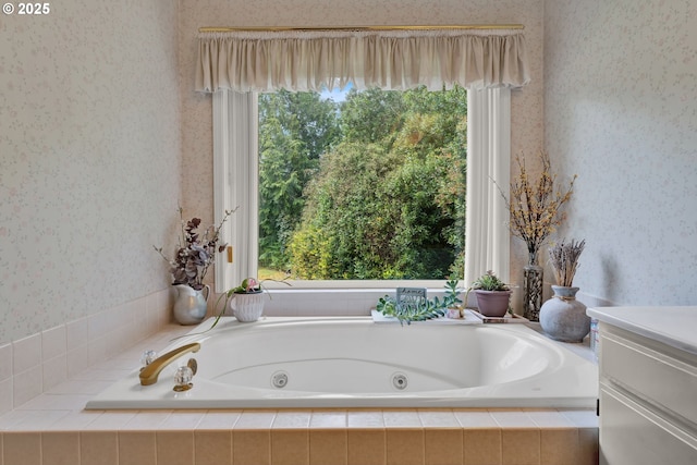 full bath with wallpapered walls, a jetted tub, plenty of natural light, and vanity
