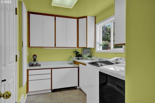 washroom with cabinet space and washer and dryer