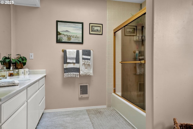 full bath featuring vanity, enclosed tub / shower combo, and heating unit