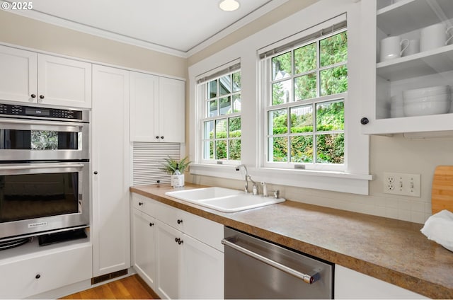 kitchen featuring appliances with stainless steel finishes, white cabinetry, and sink