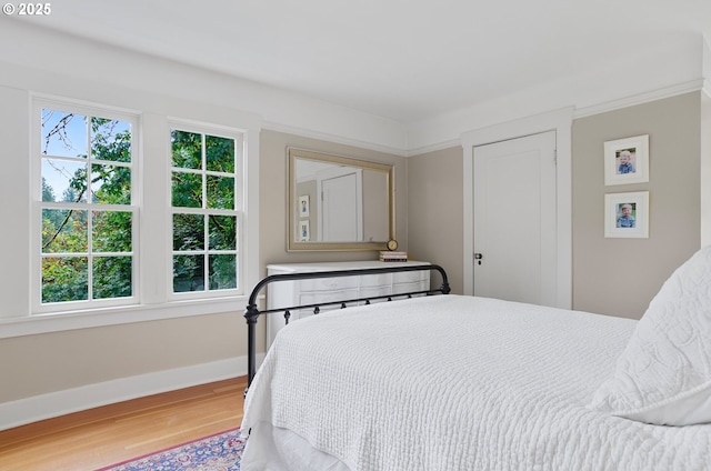 bedroom with ornamental molding and hardwood / wood-style floors