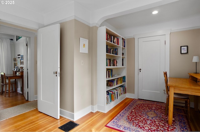 office with wood-type flooring and built in features