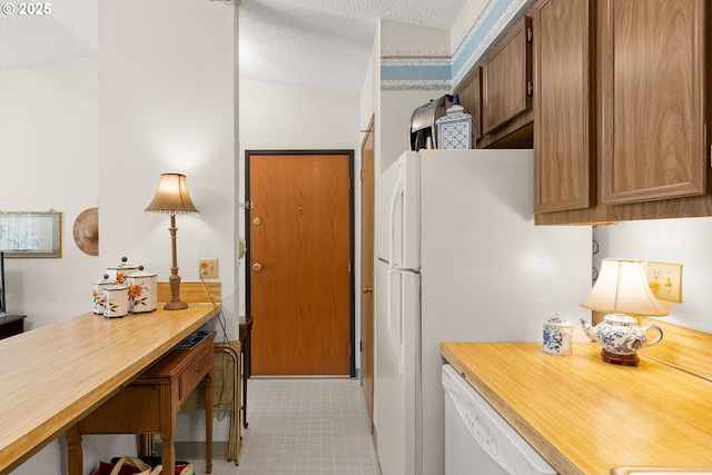 11044 SW Greenburg Rd Unit 321, Portland, OR 97223 - kitchen with a textured ceiling, white appliances, and brown cabinetry