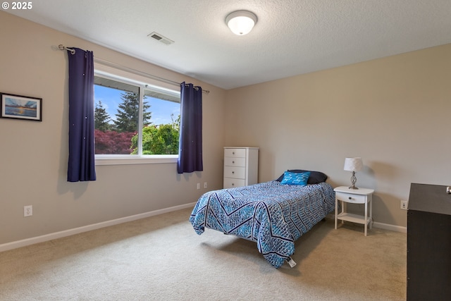bedroom featuring carpet floors, baseboards, and a textured ceiling