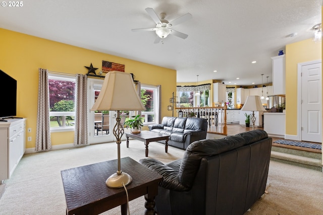 living area with a ceiling fan, light carpet, baseboards, and recessed lighting