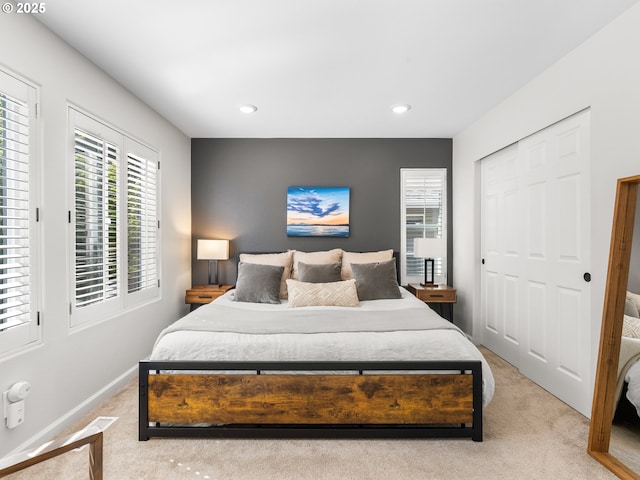 bedroom featuring recessed lighting, baseboards, a closet, and light carpet