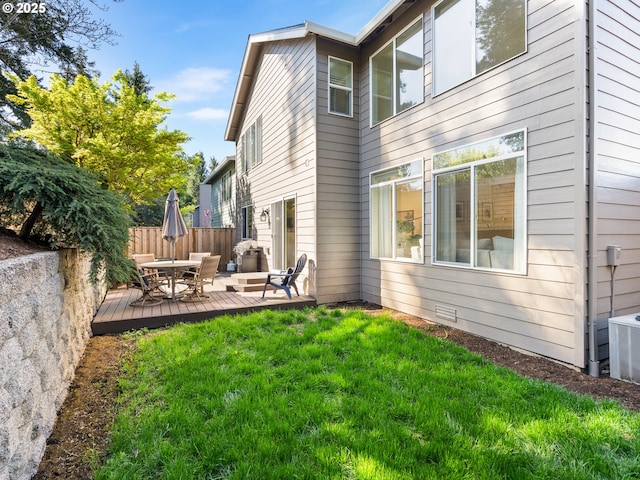 rear view of house featuring central AC unit, fence, a yard, and a wooden deck
