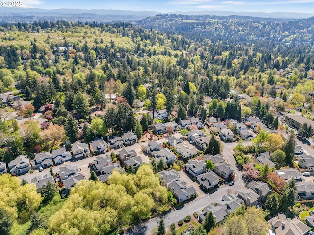 birds eye view of property featuring a view of trees, a mountain view, and a residential view