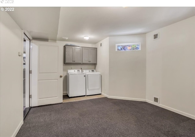 laundry room with carpet floors, washing machine and dryer, and cabinets