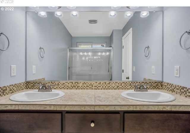 bathroom featuring vanity and a shower with door