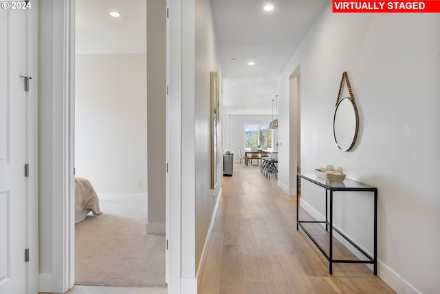 hallway with baseboards, light wood-style floors, and recessed lighting