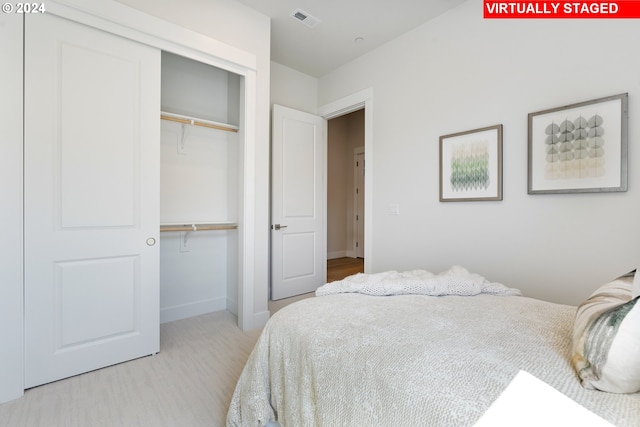 bedroom with light hardwood / wood-style floors and a closet