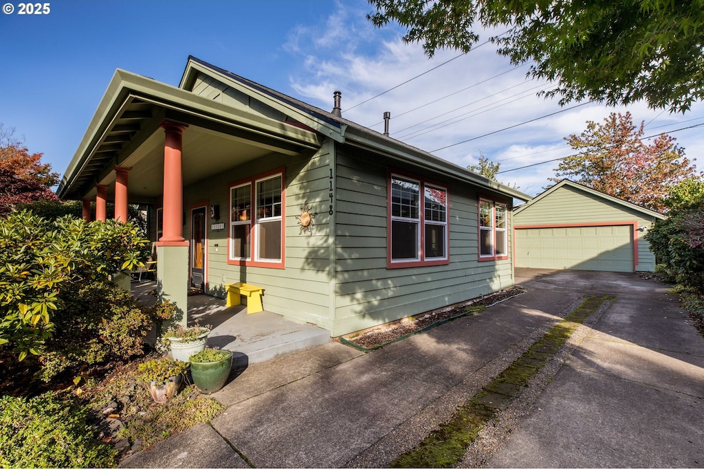 view of front of house featuring an outbuilding, a porch, and a garage