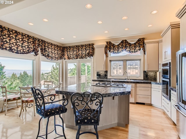 9112 NW Wiley Ln, Portland, OR 97229 - kitchen with a kitchen breakfast bar, recessed lighting, a sink, stainless steel appliances, and decorative backsplash