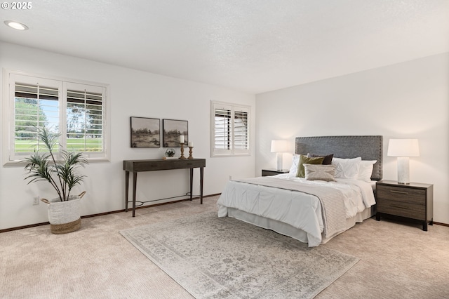 bedroom with light colored carpet, recessed lighting, and baseboards