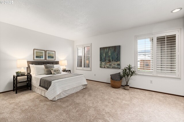 carpeted bedroom featuring a textured ceiling and baseboards