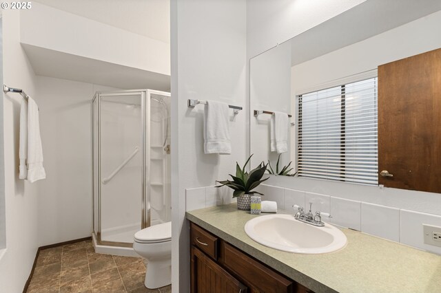 bathroom with toilet, a shower stall, tasteful backsplash, and vanity