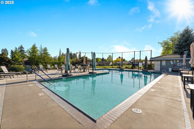 pool with a patio area and fence