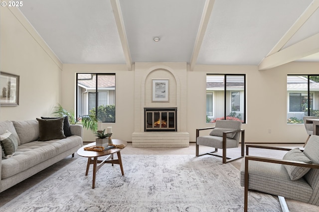 living room featuring lofted ceiling with beams and a large fireplace