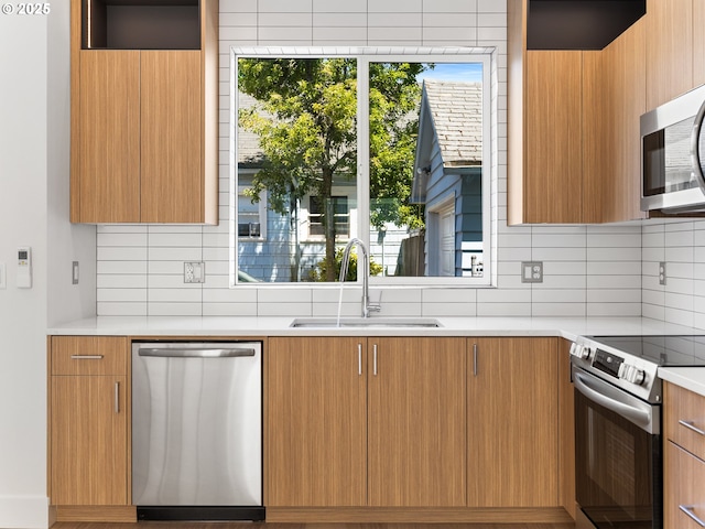 kitchen featuring decorative backsplash, stainless steel appliances, and sink