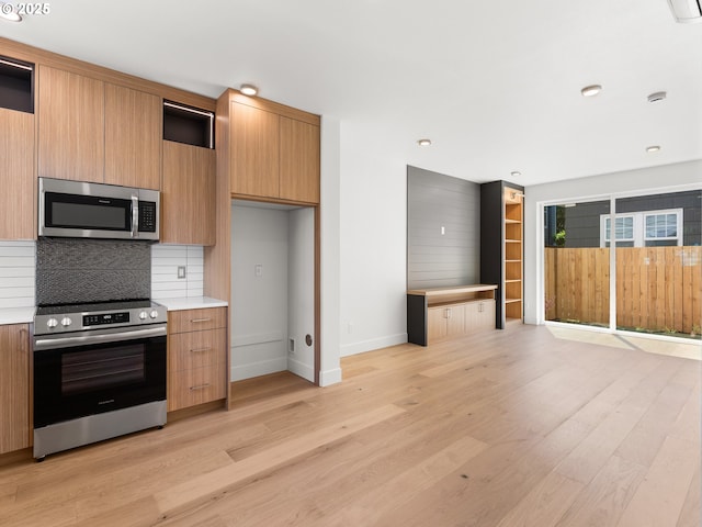 kitchen featuring backsplash, light hardwood / wood-style flooring, and appliances with stainless steel finishes