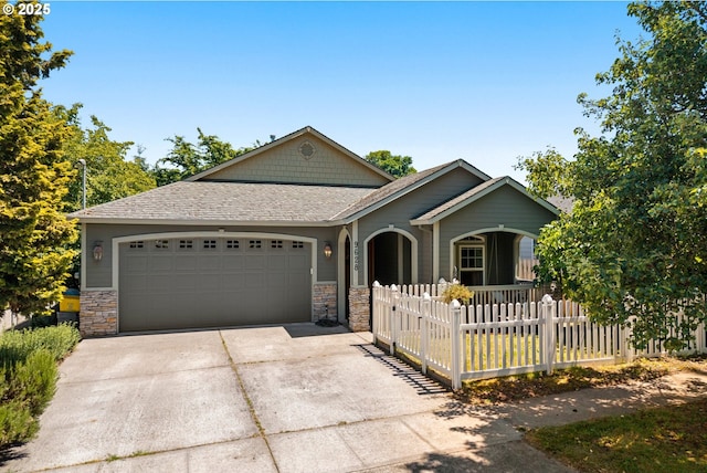 9628 N Exeter Ave, Portland, OR 97203 - view of front of property featuring concrete driveway, an attached garage, stone siding, and a porch