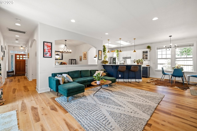 9628 N Exeter Ave, Portland, OR 97203 - living room featuring a chandelier, arched walkways, recessed lighting, and light wood-style flooring