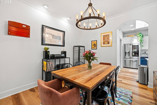 9628 N Exeter Ave, Portland, OR 97203 - dining space featuring arched walkways, a chandelier, light wood finished floors, crown molding, and recessed lighting