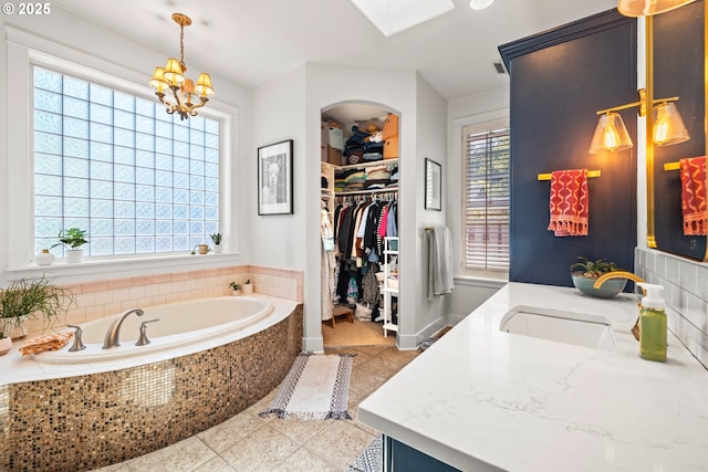 9628 N Exeter Ave, Portland, OR 97203 - full bathroom with vanity, a bath, tile patterned flooring, a spacious closet, and a chandelier