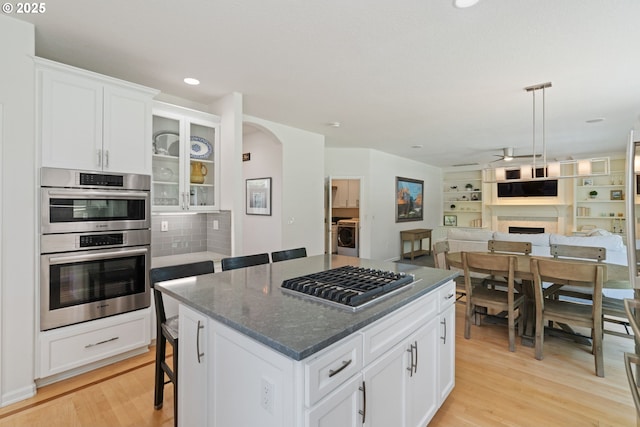 10440 SW 141st Ave, Beaverton, OR 97008 - kitchen featuring stainless steel appliances, a ceiling fan, open floor plan, light wood-style floors, and a kitchen island