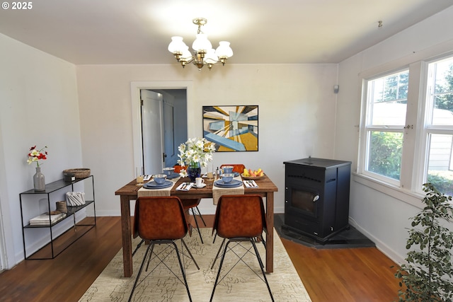 210 Holeman Ave, Eugene, OR 97404 - dining room featuring a chandelier, wood finished floors, baseboards, and a wood stove