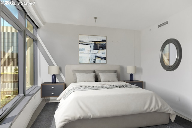 bedroom featuring baseboards, carpet flooring, and visible vents