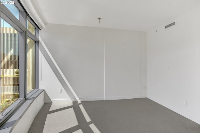 carpeted spare room featuring visible vents and baseboards