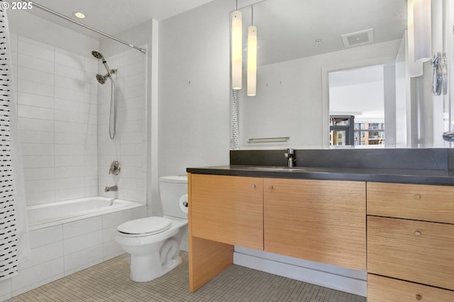 bathroom featuring visible vents, tile patterned flooring, vanity, toilet, and tiled shower / bath combo