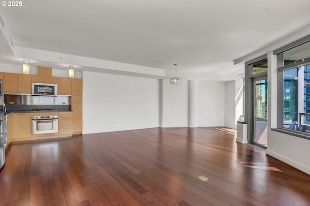 unfurnished living room featuring baseboards and dark wood-type flooring
