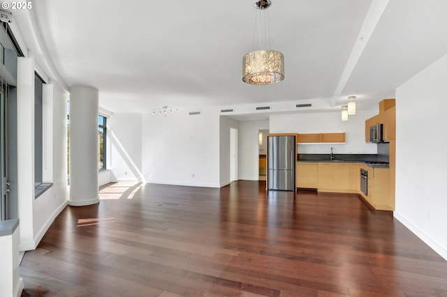 unfurnished living room featuring a sink, dark wood-style floors, and visible vents