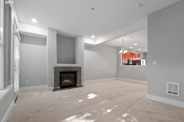 1919 NE 50th Way, Hillsboro, OR 97124 - unfurnished living room featuring light colored carpet, a chandelier, a fireplace with flush hearth, recessed lighting, and baseboards