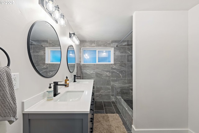 bathroom with tile patterned floors, vanity, and a tile shower