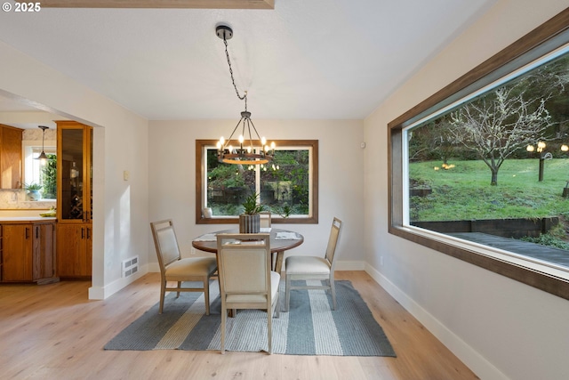 dining room featuring light wood-type flooring and a chandelier