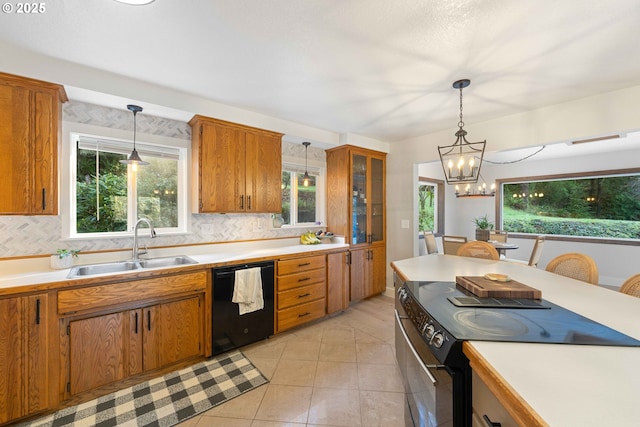 kitchen with pendant lighting, black appliances, sink, tasteful backsplash, and a notable chandelier