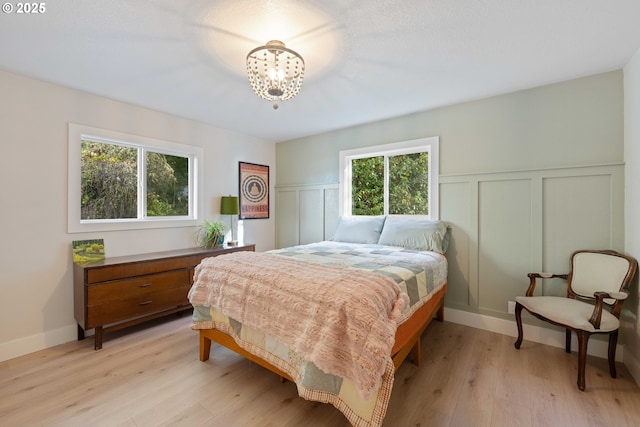 bedroom featuring light hardwood / wood-style flooring and an inviting chandelier