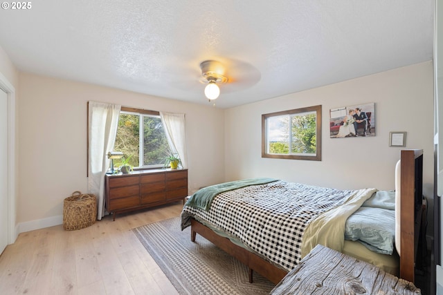 bedroom featuring a textured ceiling, light hardwood / wood-style flooring, and ceiling fan