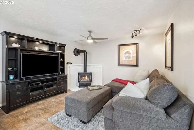 19580 SW 56th Ct, Tualatin, OR 97062 - living area featuring a wood stove, a ceiling fan, a textured ceiling, and light stone finish floors